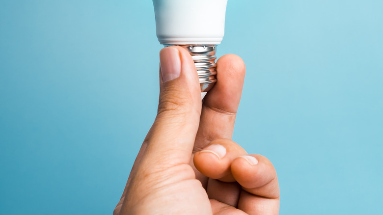 A person holding an LED lightbulb.
