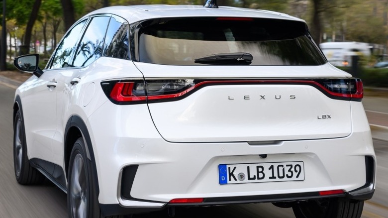 Rear action shot of a white Lexus LBX showing the LBX moniker