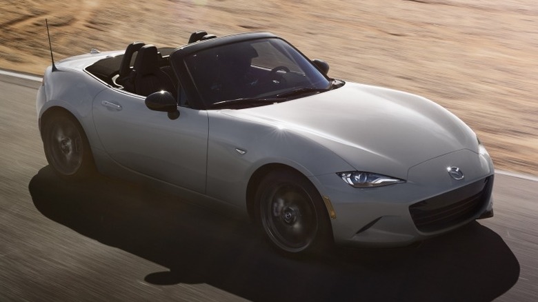 Front 3/4 shot of a Mazda MX-5 Miata driving on a paved surface