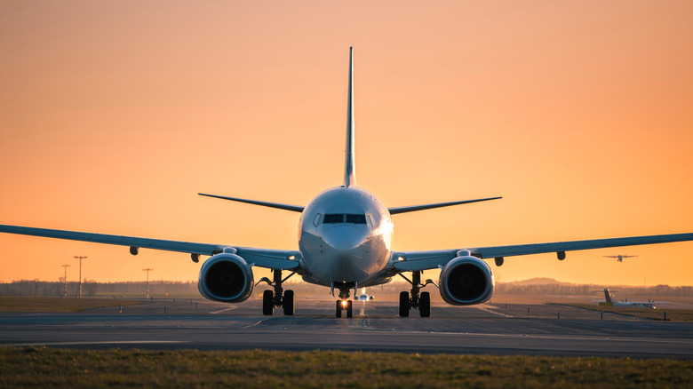 Sunset view of planes arriving and departing from an airport