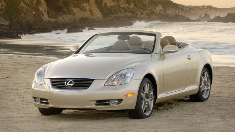 A gold Lexus SC 430 on a beach, front 3/4 view