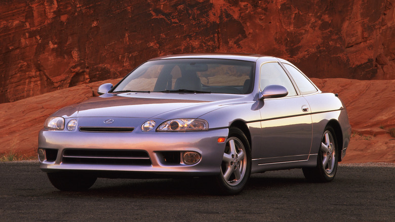 A silver first generation Lexus SC 300, front 3/4 view, canyon background