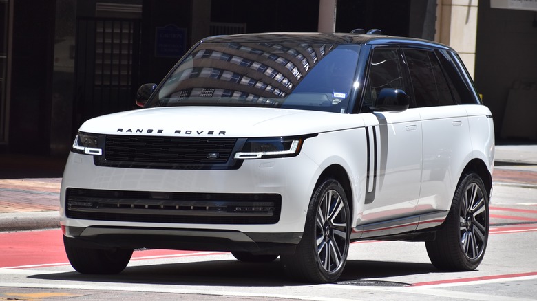 A white Range Rover parked by a sidewalk