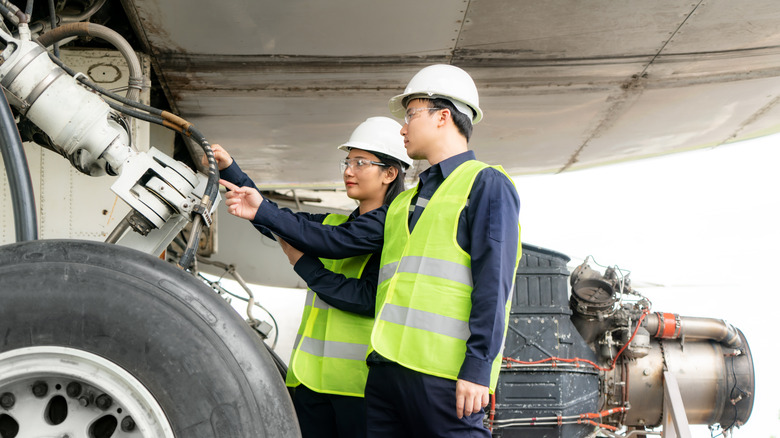 Aircraft technicians inspecting landing gear