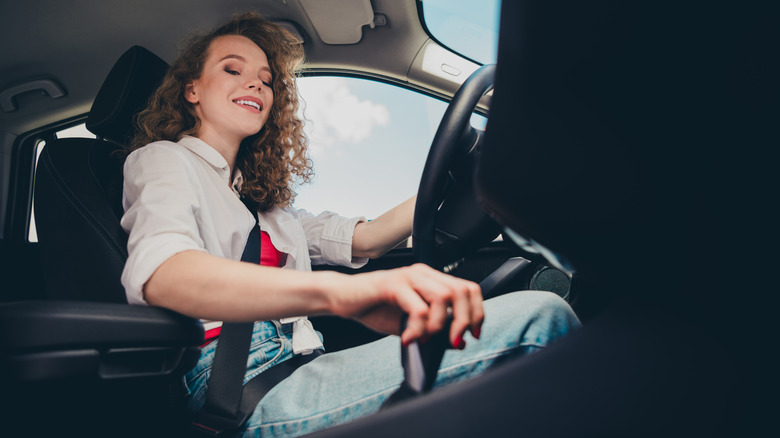 Woman controlling car gear shift