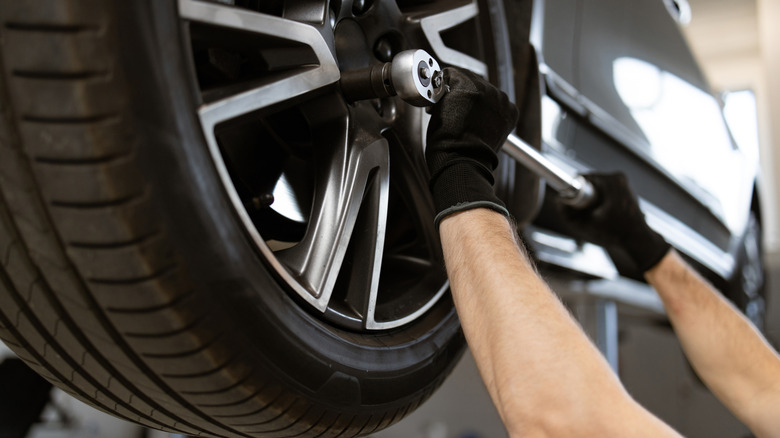 Mechanic changing lug nuts for tire replacement