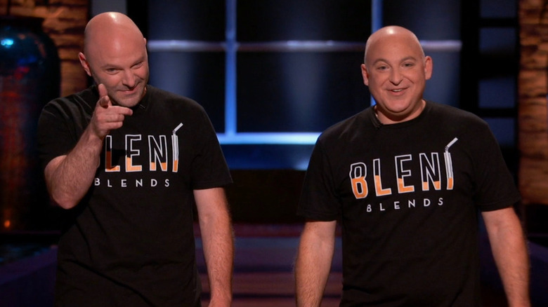 Stuart standing as Peter winks and points on Shark Tank