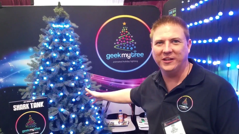 Brad at a tech showing pointing at a Christmas tree