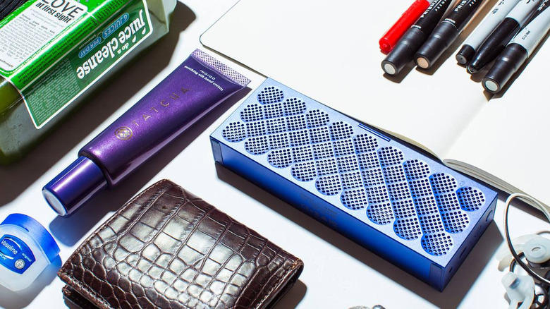 Jambox speaker next to pens and wallet