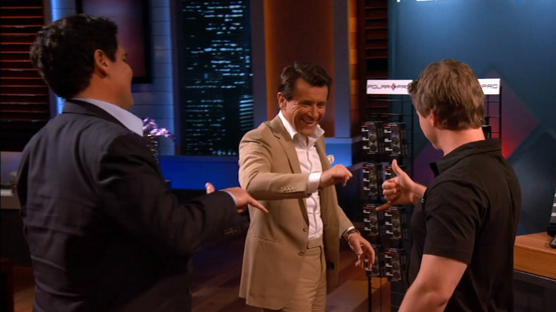 Jeff, Mark, and Robert exchanging hand gesture on Shark Tank