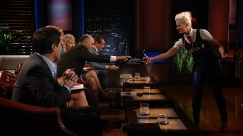 Lori handing out Cheekd cards to investors on Shark Tank