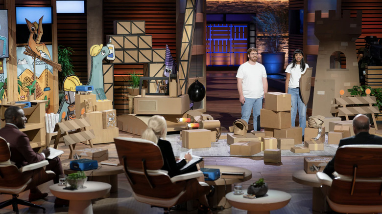 ChompShop co-founders Max Liechty and Kausi Raman standing amongst boxes on Shark Tank