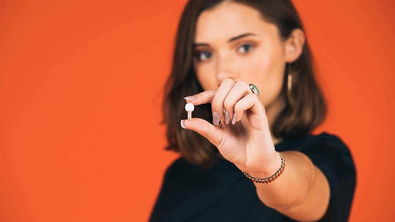 woman holding Vibes earplug