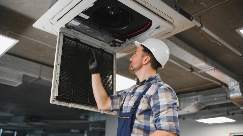 HVAC technician inspecting filter of a unit during maintenance