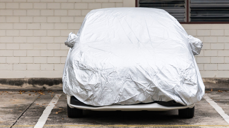 A car parked outside under a car cover.