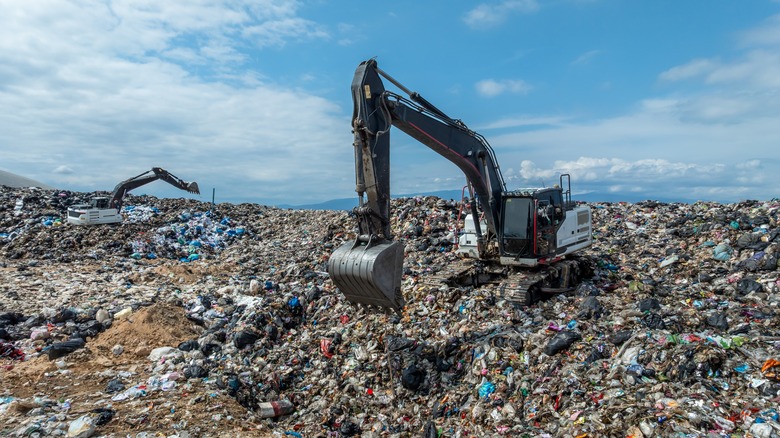 Heavy equipment moves garbage in a landfill