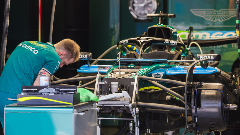 Aston Martin mechanic working on suspension in garage