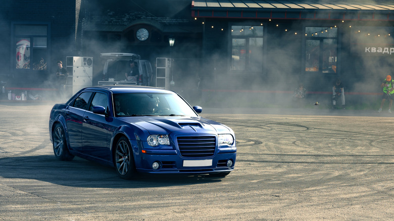 A blue Chrysler 300C sedan doing burnouts and an event