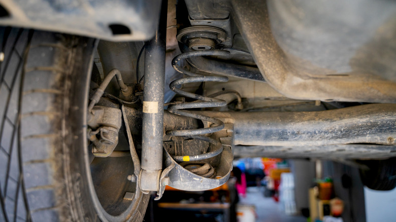 Close-up of a vehicle's rear suspension, showing shock absorber and coil spring
