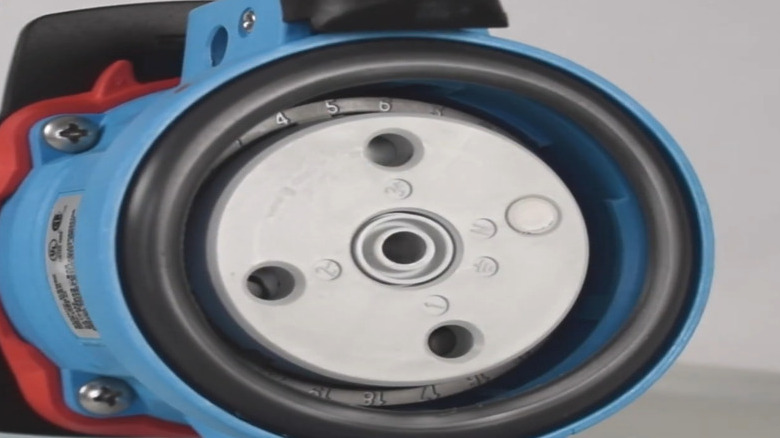 A close up of a blue, black, white, and red Meltric plug receptacle.