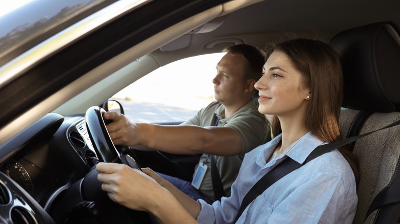 A driving instructor guiding a student