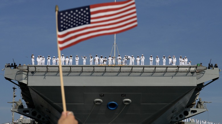 A U.S. flag in front of a carrier