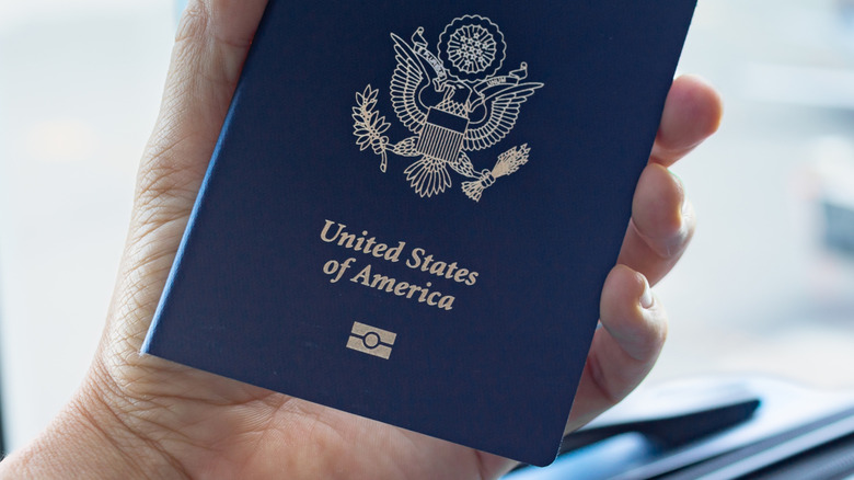 A person holding passport in hand at airport