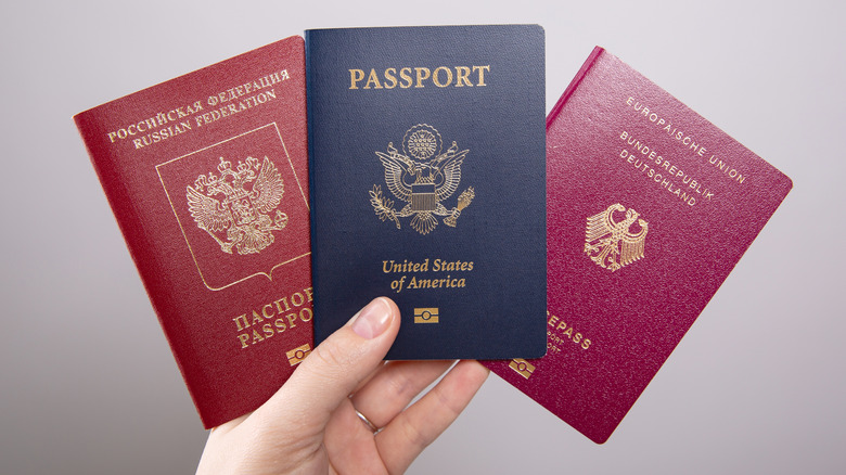 Female hand holding three passports in her hand
