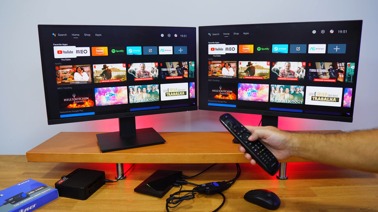 Two monitors connected to HDMI splitter on a table