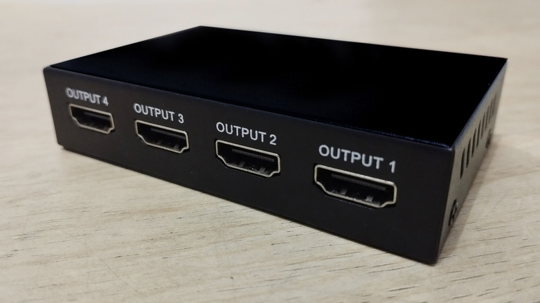 Close up of a black HDMI splitter with four output ports