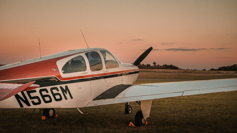 An aircraft on the runway in front of the sunset.