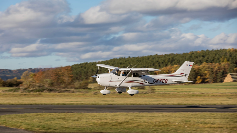 A Cessna aircraft flying just above the runway.