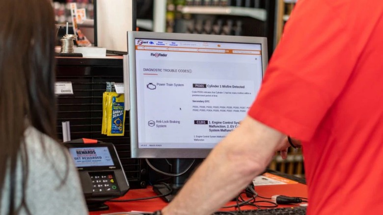 an autozone employee helping a customer use the fix finder program
