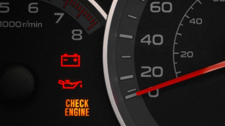 a car's dashboard displaying the check engine light, battery light, and oil pressure light