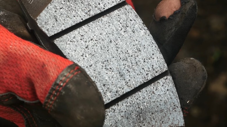 an up close image of a person holding a glazed brake pad