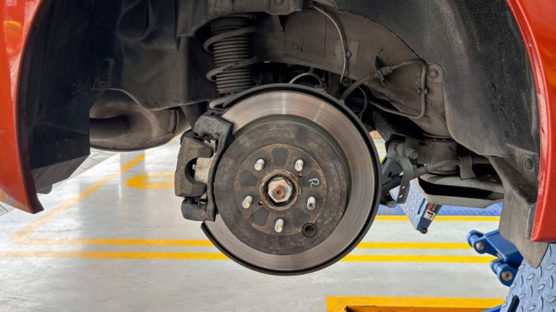 an image of a red car with the front wheels off showing the disc brake system