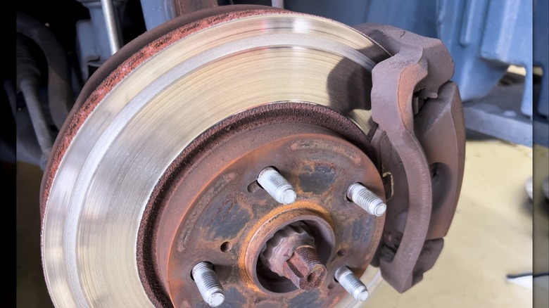 An image showing a badly worn disc brake rotor on an automobile.