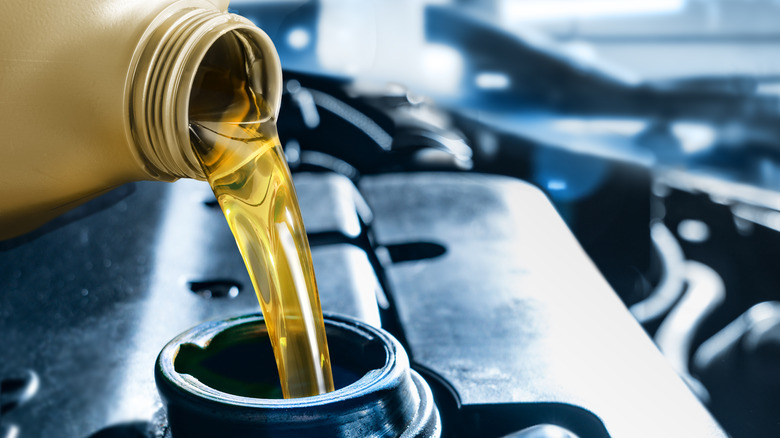 Close up shot of fuel being poured out of a bottle into an engine =
