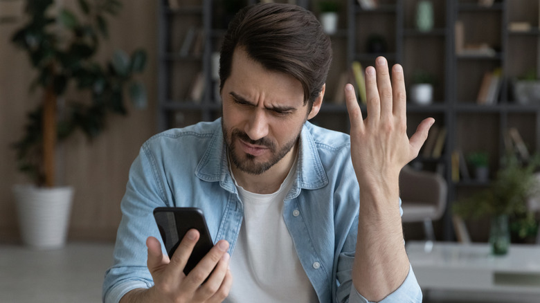 Person looking frustrated at his phone