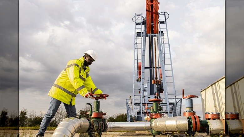 Oil worker in front of pumpjack