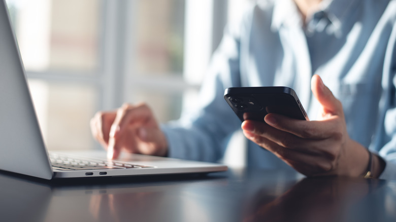 A person using a phone and mobile device