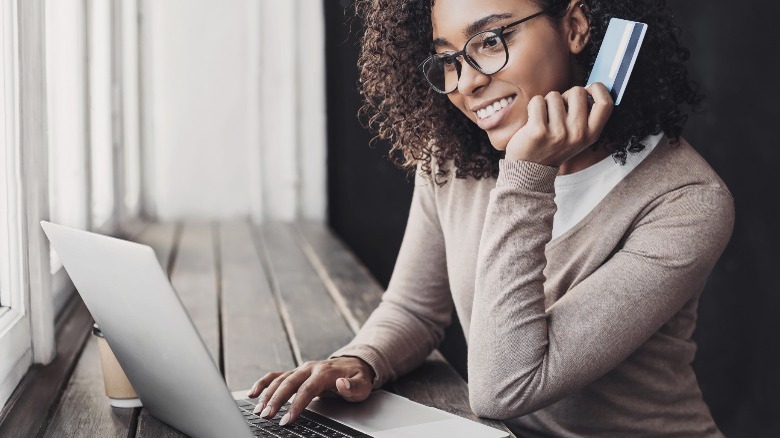 Person at laptop with credit card in hand