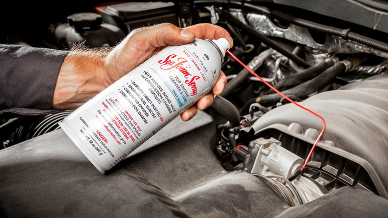 Man using Sea Foam Spray to clean a car engine