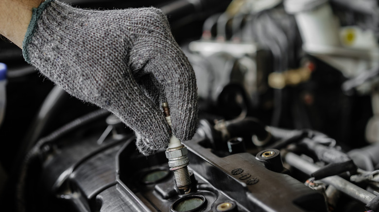 Close-up of service echnician servicing a car's spark plugs