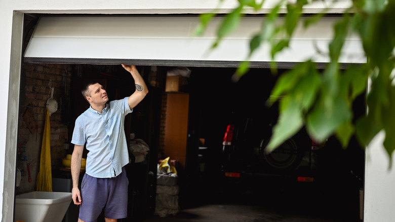 young adult man lifting gates of the garage