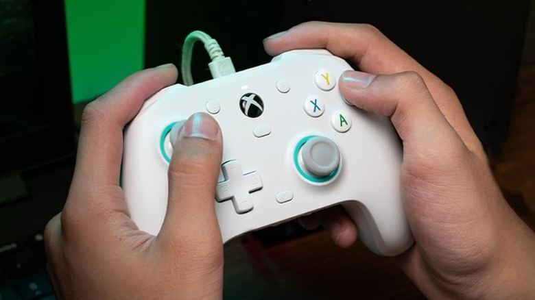 A person using a GameSir G7 SE controller.