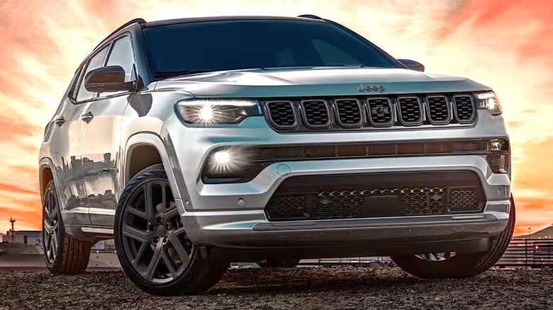 A Jeep Compass in the mountains with the sun blazing behind it.
