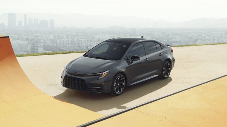 Black Toyota Corolla parked above a city skyline