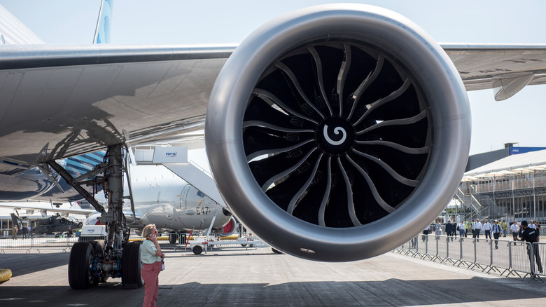 A person standing next to a General Electric GE9X engine