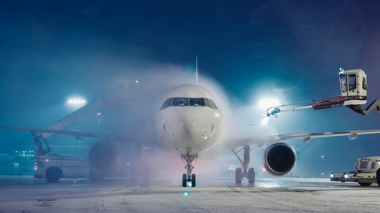 Plane being de-iced before flight in winter
